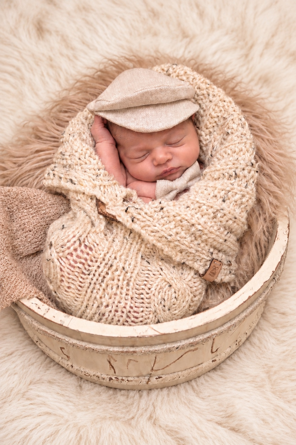 Neugeborenes in einer Schale mit Strickdecke